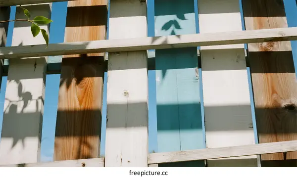 Wooden Fence with Blue and Brown Patterns in Sunlight