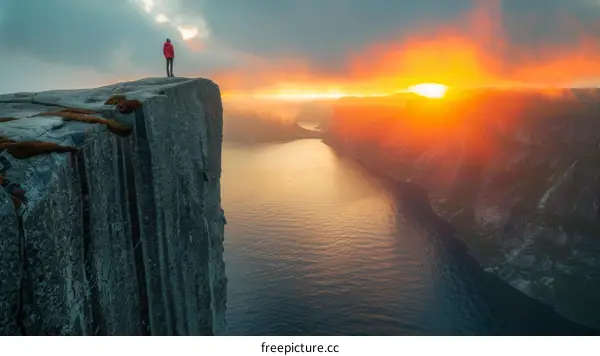 Man standing on a cliff overlooking a fjord in Norway