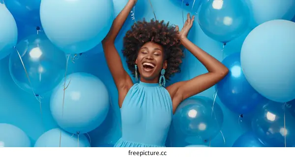 Happy African American woman having fun with blue balloons