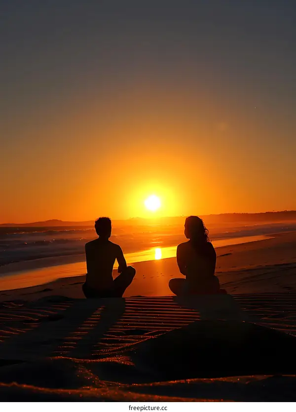 Silhouettes of a Couple Sitting on Beach at Sunset