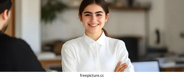 Smiling Businesswoman With Crossed Arms In Office