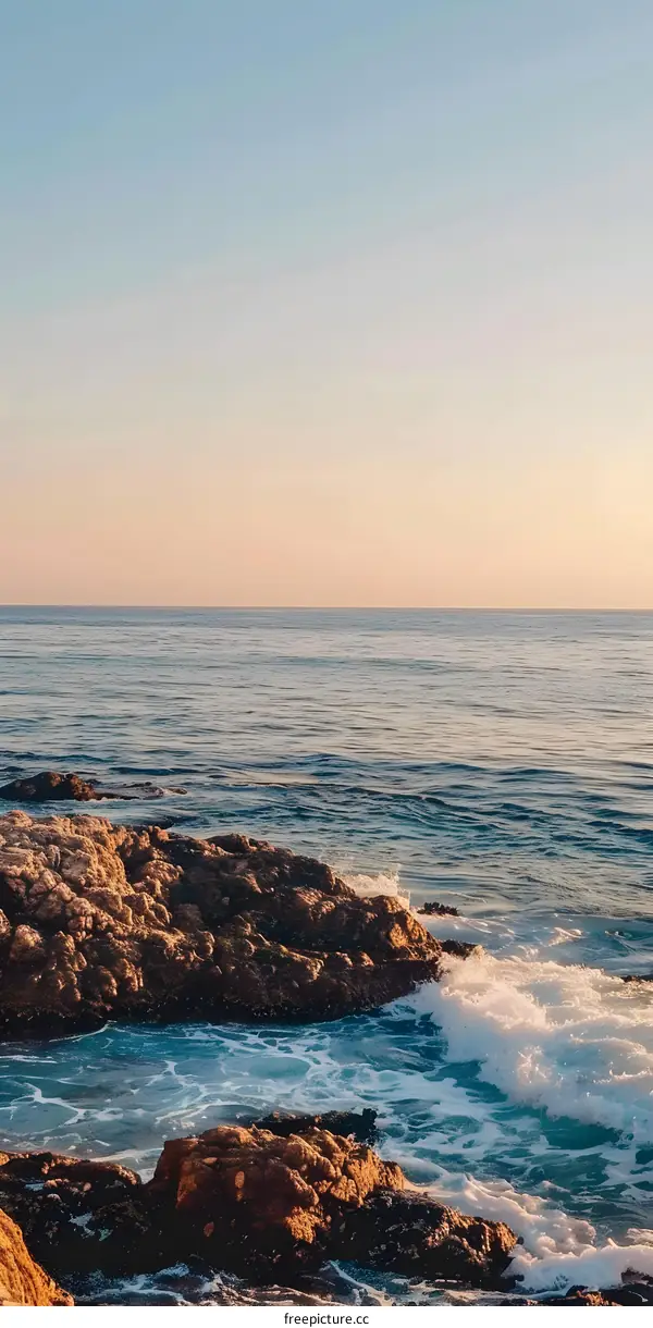 Ocean Waves Crashing Against Rocky Shore at Sunset