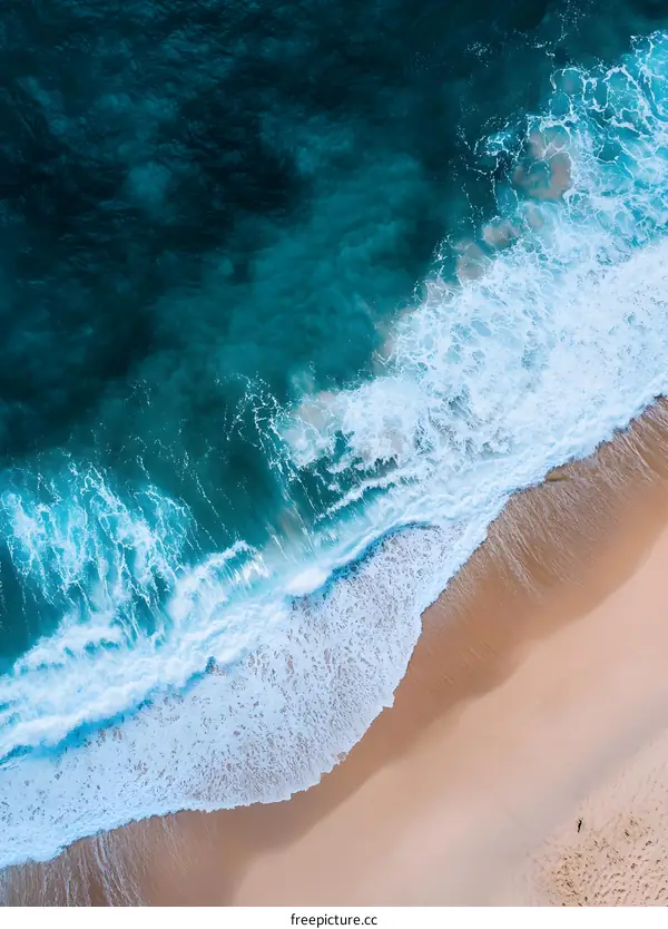 Aerial View Of Ocean Waves Crashing On Sandy Beach