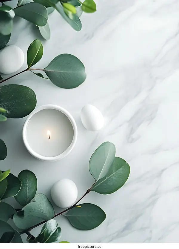 White Candle with Green Leaves on Marble Background