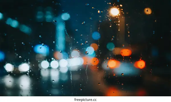 Rainy Night Street with Blurred Lights and Water Drops on Window
