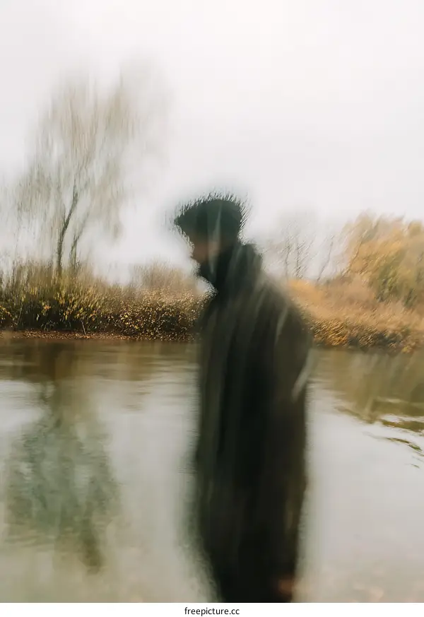 Blurry Man Walking Through River in Autumn