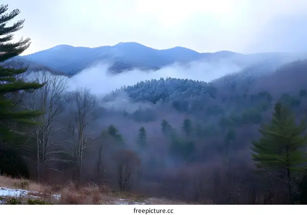 Mountain Range Covered In Fog And Snow