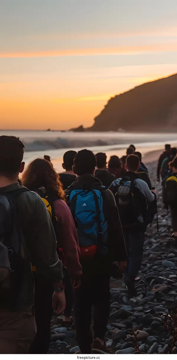 Group of People Walking on the Beach at Sunset