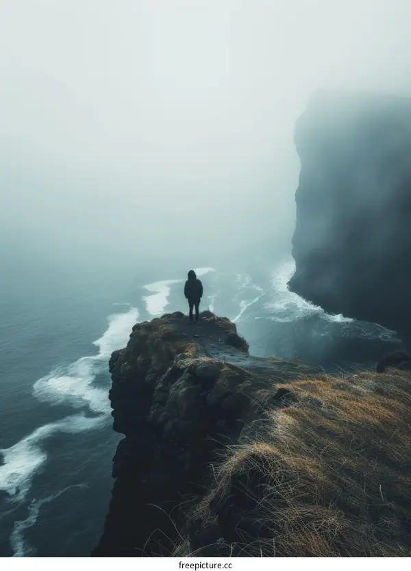Man standing on a cliff overlooking the ocean