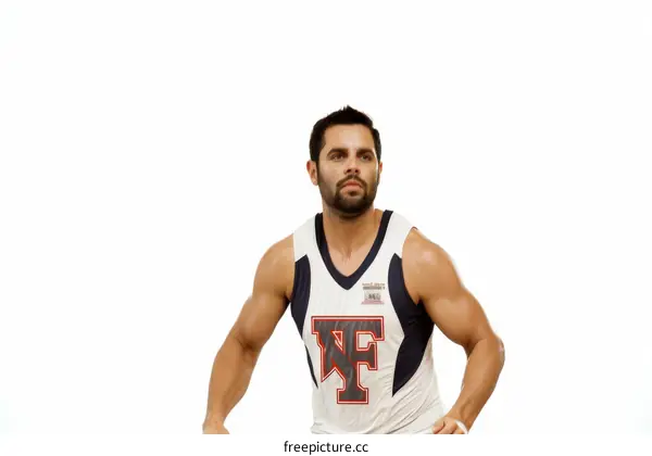 A young male basketball player in a white jersey with a red and blue stripe on the side dribbles the ball.