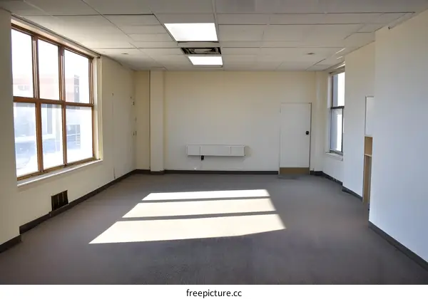 Empty Office Space with Large Windows and Sunbeams