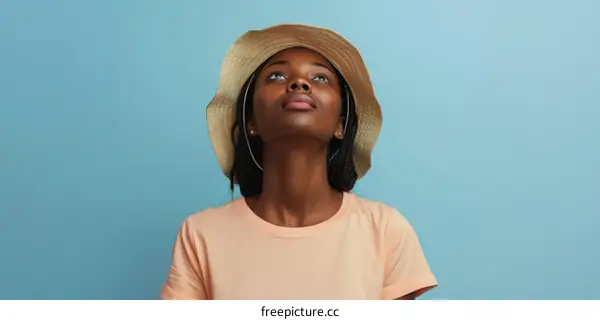 Young African-American woman wearing a hat looking up