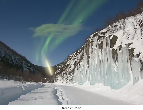 Northern Lights Display Over Snow Covered Mountain Range