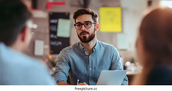 Young Man Talking to Colleagues During a Business Meeting