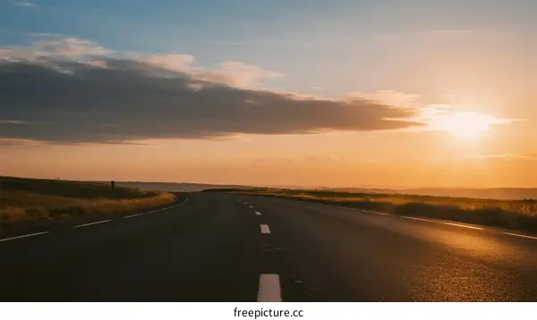 Sunset over an empty road with clear sky and clouds