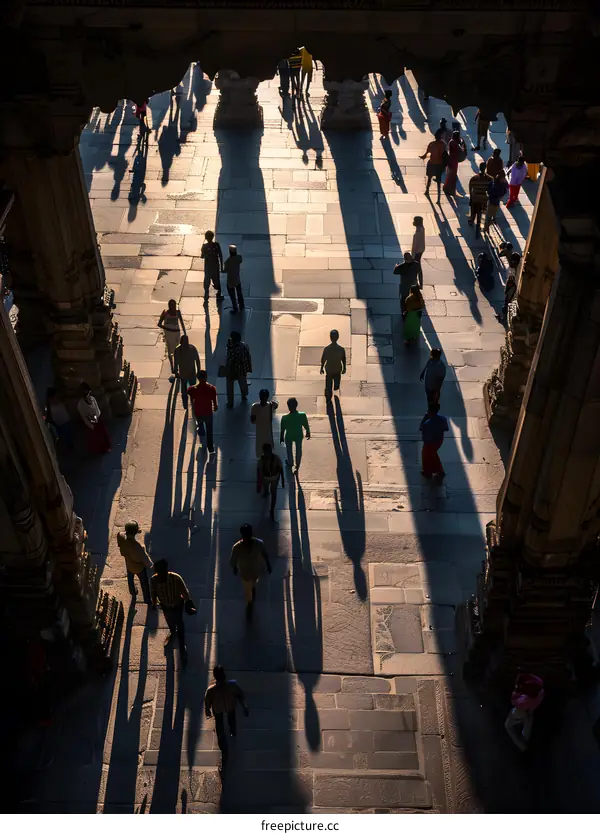 People Walking in the Shadow of a Temple in India