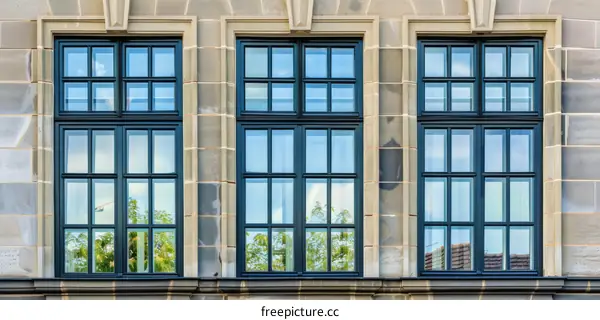 Three Dark Blue Windows on a Beige Stone Building Facade