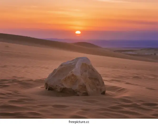 Golden Sunset Over Vast Desert Landscape with Isolated Rock