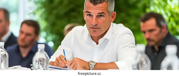 Businessman Taking Notes During a Meeting with Other Businessmen in a Modern Office