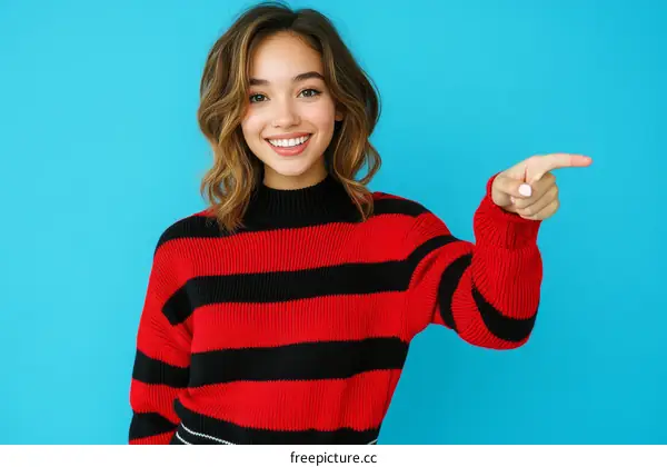 Smiling Woman in Red and Black Striped Sweater Pointing