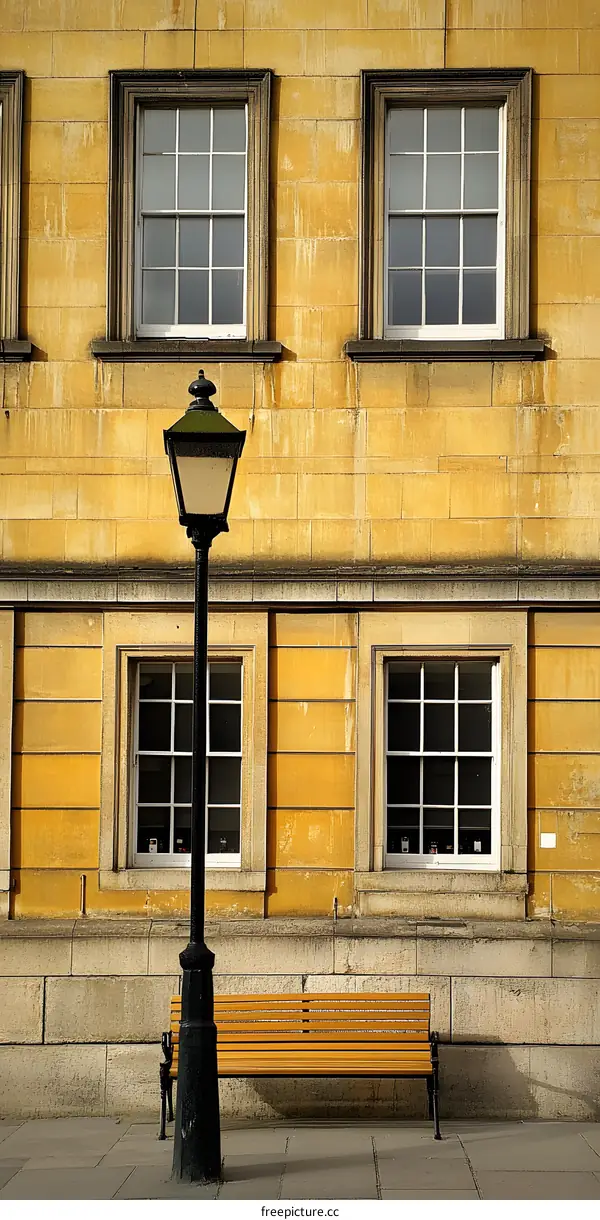 Yellow Building with a Street Lamp, a Wooden Bench, and Windows