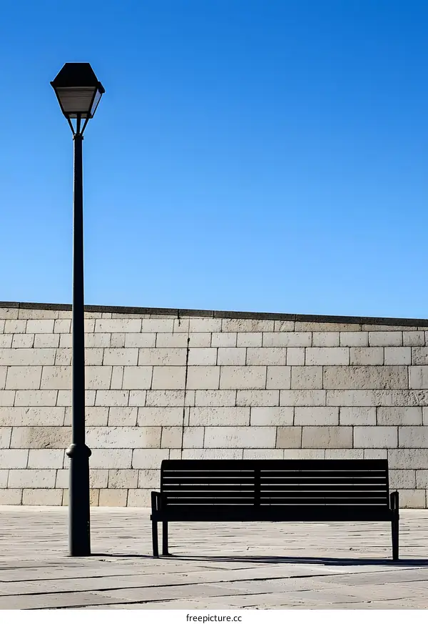 Black Bench and Streetlight in Front of a Brick Wall