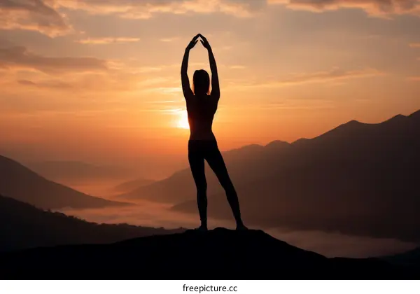 woman silhouette on the mountaintop at sunset with raised arms
