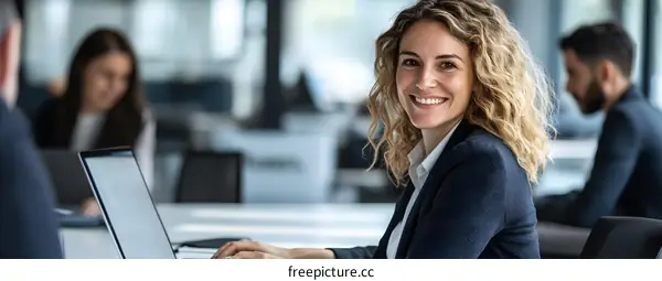 Smiling Businesswoman Working on Laptop in Office