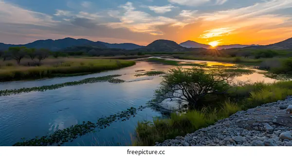 Sunset Over the River with Mountains in the Background