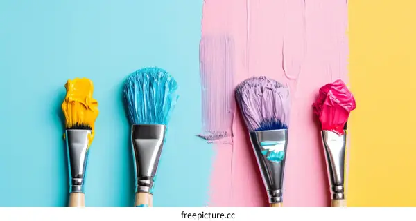 Four Paintbrushes with Colorful Paint on a Blue, Pink, and Yellow Background