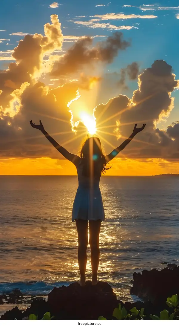 Silhouette of a Woman with Her Arms Raised as the Sun Rises Over the Ocean