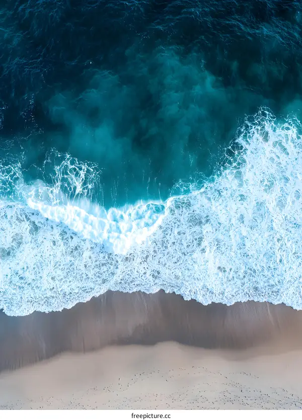 Aerial View of Blue Ocean Waves Crashing on Sandy Beach