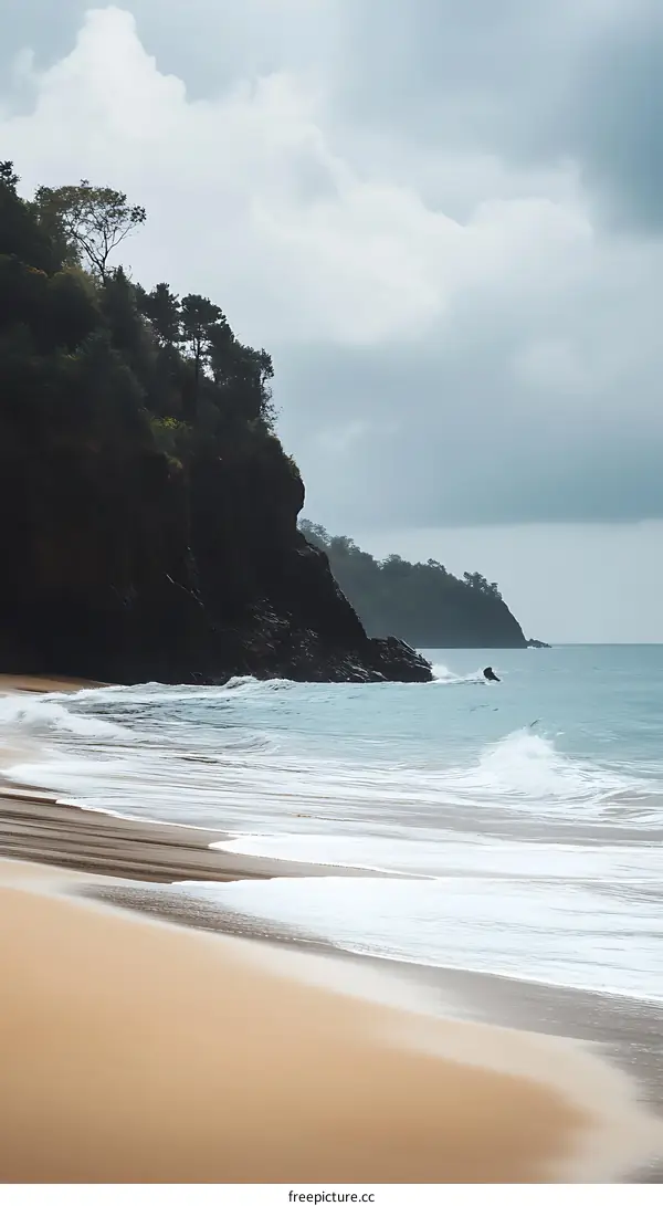 Sandy Beach With Cliffside Background Under A Cloudy Sky