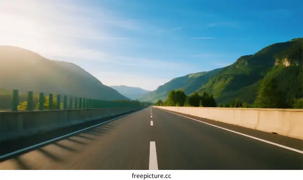 A scenic highway with mountains and clear sky in the distance