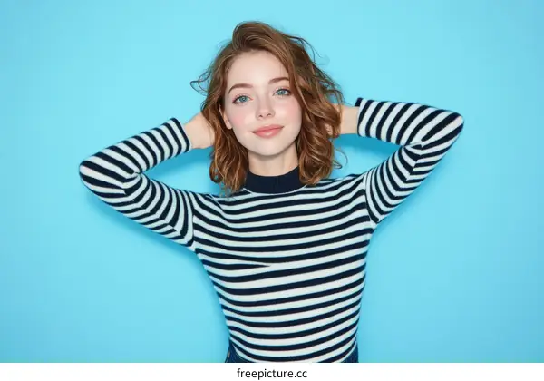 Young Woman in Striped Sweater Against a Blue Background