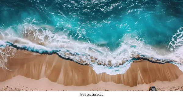 Aerial View of Ocean Waves Crashing on Sandy Beach
