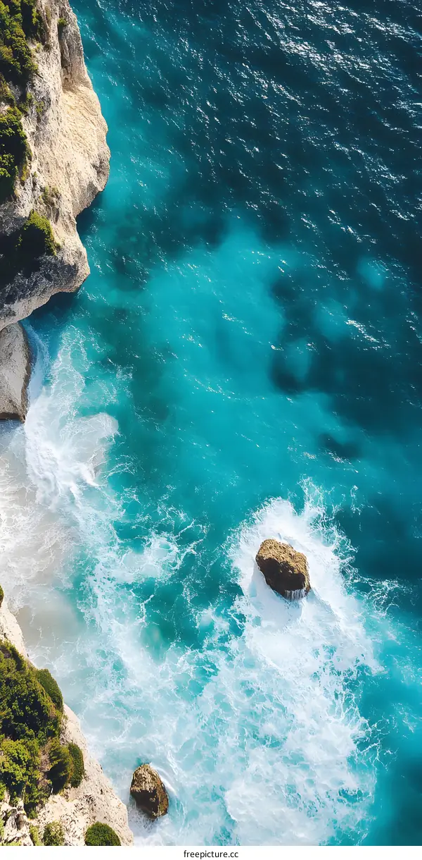 Aerial View of the Ocean with White Waves Crashing Against Rocks