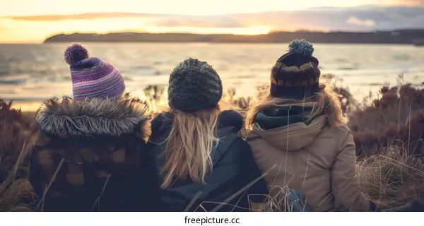 Three Friends Watch Sunset on the Beach