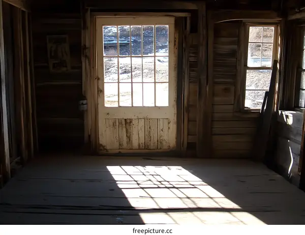Sunlight Streaming Through an Old Wooden Door in an Abandoned Building