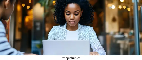 Young African American Woman Working on a Laptop in a Cafe