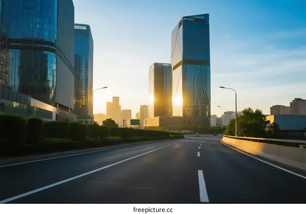 Sunset view of modern city road with tall buildings