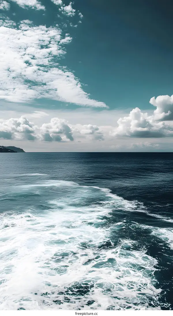 Ocean Water With White Foam and Clouds