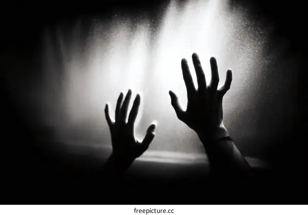 Two Hands Pressing Against Glass with Light Shining Through