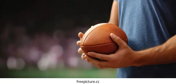 Man holding American Football in Stadium