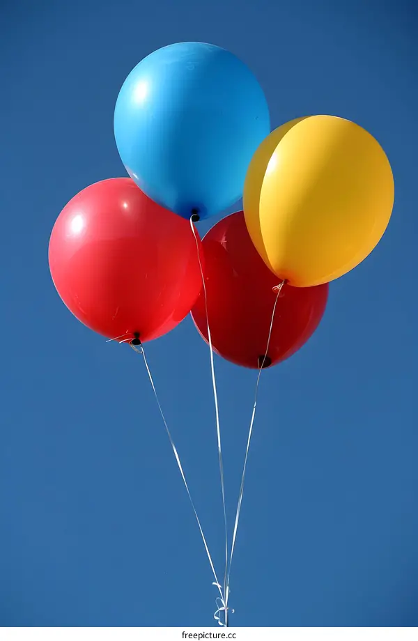 Four Colorful Balloons Floating In The Blue Sky