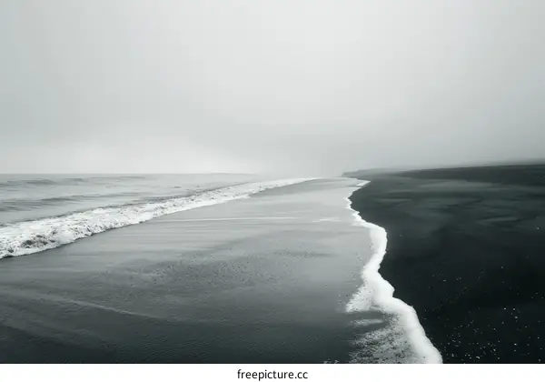 Black sand beach with a small wave