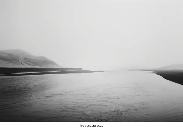 Black and white photo of a river flowing through a valley