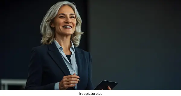 Smiling Businesswoman in Suit Holding Tablet
