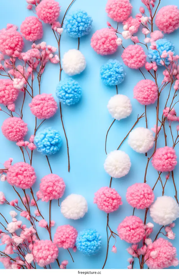 Pink Blue White Pom Poms and Branches on Light Blue Background