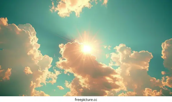 Sun shining through clouds in a teal sky
